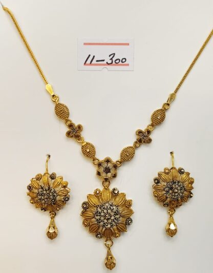 Indulge in timeless elegance with this meticulously crafted 21k gold necklace and earring set, featuring a captivating floral design.