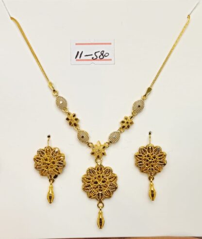 This elegant 21ct gold necklace and earring set features a classic flower design. The necklace has a delicate chain and a beautiful flower pendant, crafted with approximately 1 tola of 21ct gold. The earrings match the pendant's design.