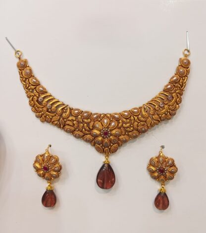 A gracefully designed 21K gold Madrasi choker necklace set with intricate patterns and brown teardrop pendants, complemented by matching earrings.