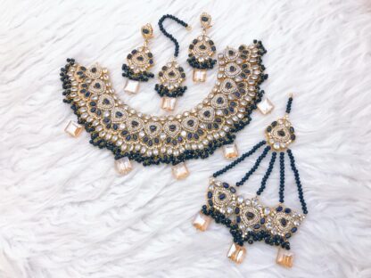 Luxurious Kundan choker set in gold and midnight blue, adorned with intricate beadwork, gemstones, and matching accessories.