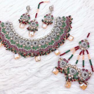 Traditional gold and ruby red Kundan choker set with intricate detailing, bead embellishments, and matching earrings, tikka, and hand jewelry.