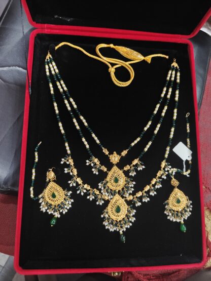 2 Tola Bridal 21K gold necklace set with green beads, filigree pendant, pearl drops, and matching earrings in red velvet box.