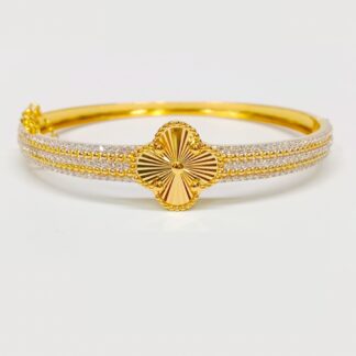 Luxurious 14.500 Grams gold bangle with a central sunburst clover design and a thick band encrusted with double rows of white stones and gold beads.