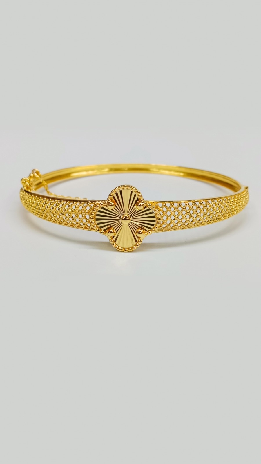 Luxury 22ct Gold Bangle Collection: Clover Designs and Intricate Finishes Lightweight 13.000 Grams gold bangle showcasing a central clover sunburst motif and a beautifully detailed, wide filigree mesh band.
