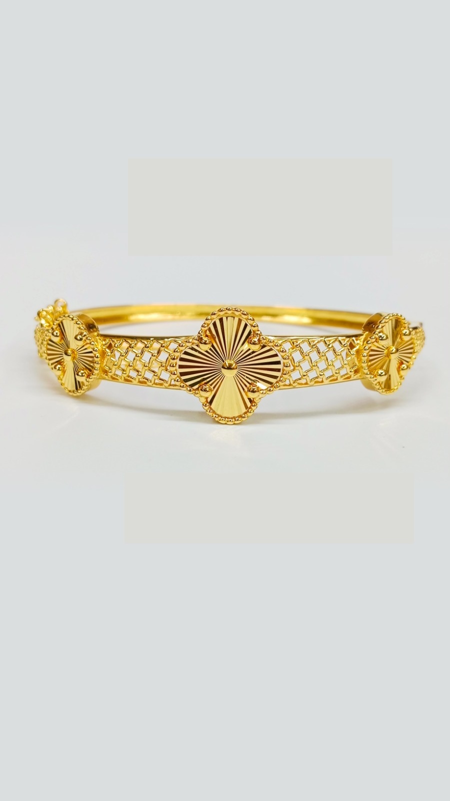 Luxury 22ct Gold Bangle Collection: Clover Designs and Intricate Finishes Heavy 15.600 Grams gold hinged bangle featuring three clover-style charms set on a wide, detailed lattice or open-work band.