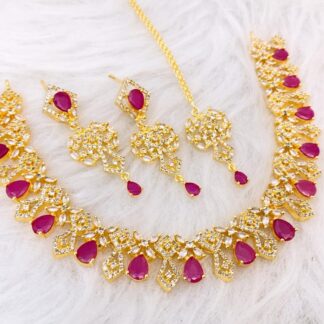 Traditional ruby red and gold jewelry set with fringe necklace, earrings, and maang tikka.