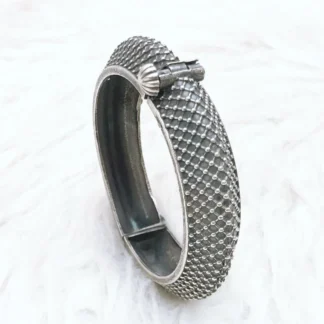 Heavy textured oxidized silver bangle with industrial mesh pattern and secure shell-shaped hinge clasp for gothic luxury fashion.
