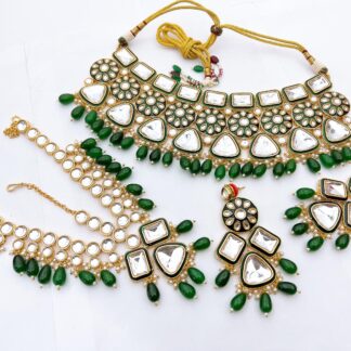 Luxurious Emerald Green Meenakari Kundan bridal choker set with teardrop green beads, matching statement earrings, and maang tikka.