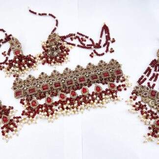Full Pakistani bridal dulhan jewelry set in red and white featuring a heavy choker, jhumka earrings, and a jhumar with ruby stones and pearl hangings.