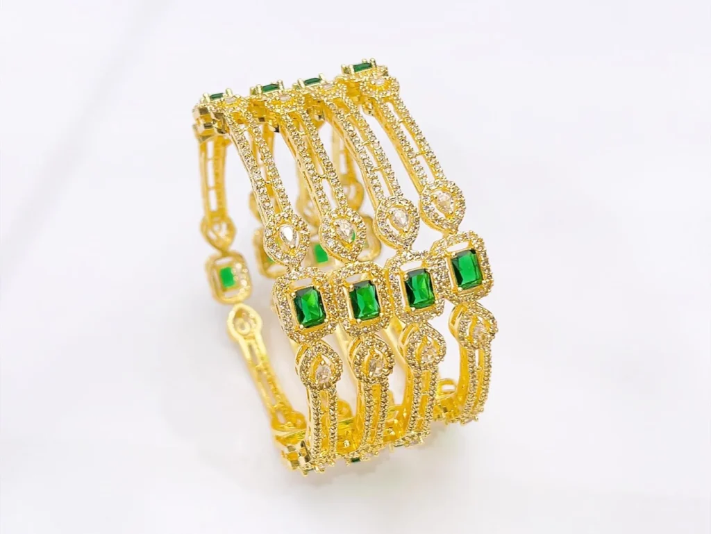 Discover the latest American Diamond bangles set in India featuring emerald green stones and brilliant AD sparkle. Crafted in gold-plated finish, this bridal and party wear bangle set is ideal for weddings, Diwali, and festive occasions. Elegant stacking design with premium shine.