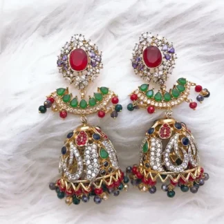 Ornate multi-stone jhumka earrings featuring a prominent central red gemstone stud surrounded by sparkling clear and multicolored stones, a graceful hanging crescent tier adorned with vibrant green stones, detailed domed bells with intricate white stone settings, and multi-colored beaded dangling fringes.