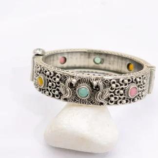 Shop a multicolor filigree cuff bracelet with pink, green and yellow decorative stones, ornate silver-tone detailing and a bold statement design.