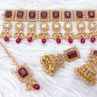 Shop our handcrafted gold-plated ruby red Kundan choker necklace set with matching Jhumka earrings and Maang Tikka. Perfect for weddings, luxury events, and ethnic celebrations.